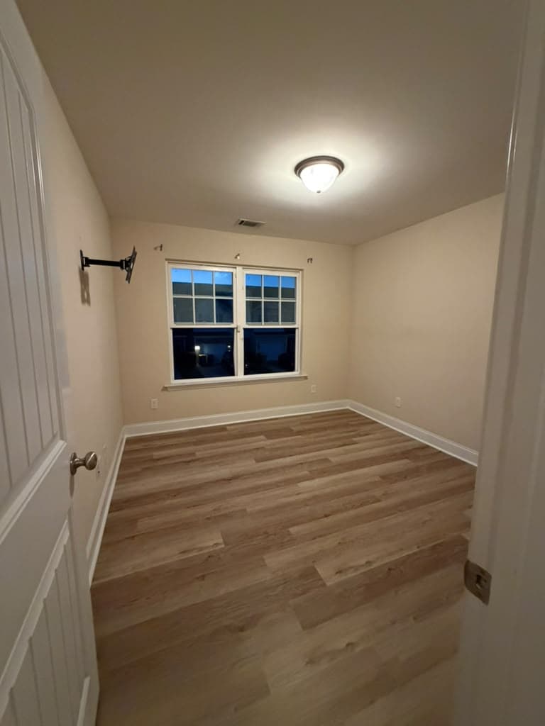 Bedroom with new LVP flooring and white baseboards