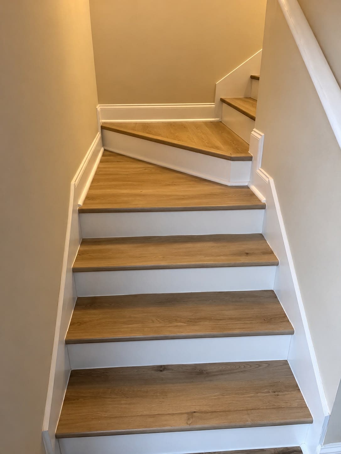 Finished winder staircase with LVP treads and white risers