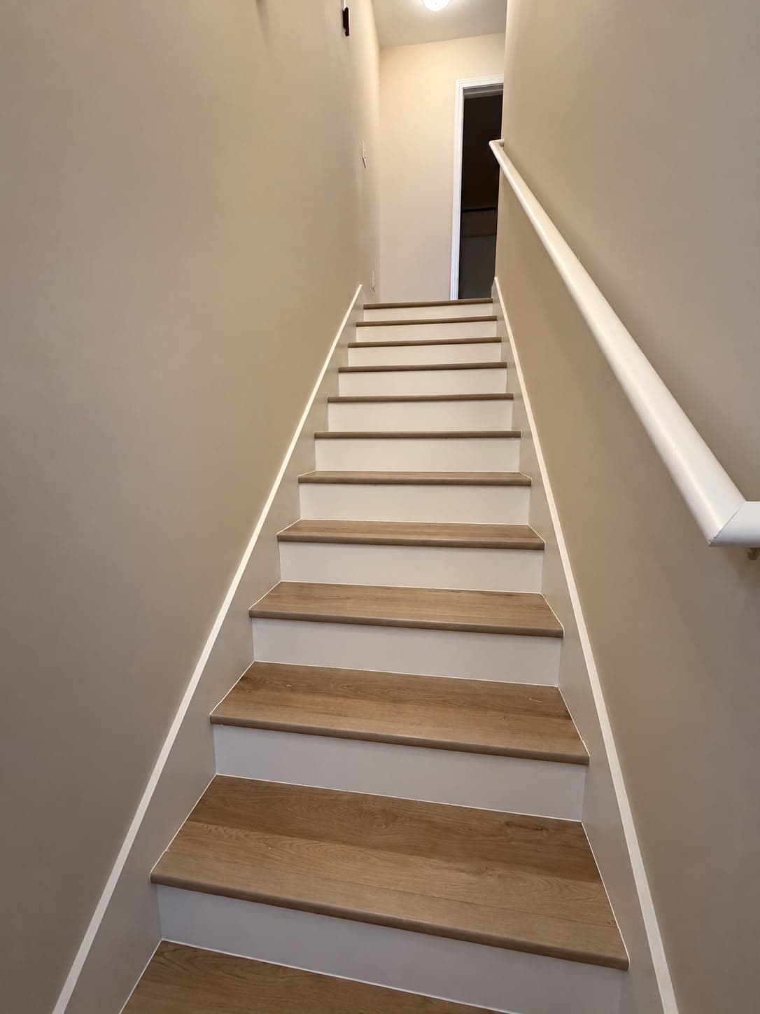 Straight staircase with new LVP treads, white risers and handrail